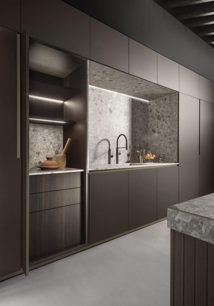 Custom designed kitchen wall unit with central open niche in grey stoneware housing the sink. Pocket door tall cabinets on each side.