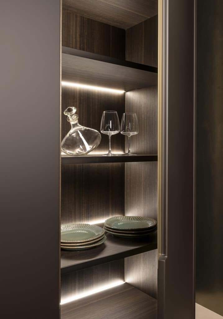 Luxury tall kitchen cabinet with interior in eucalyptus and LED-lit shelves.