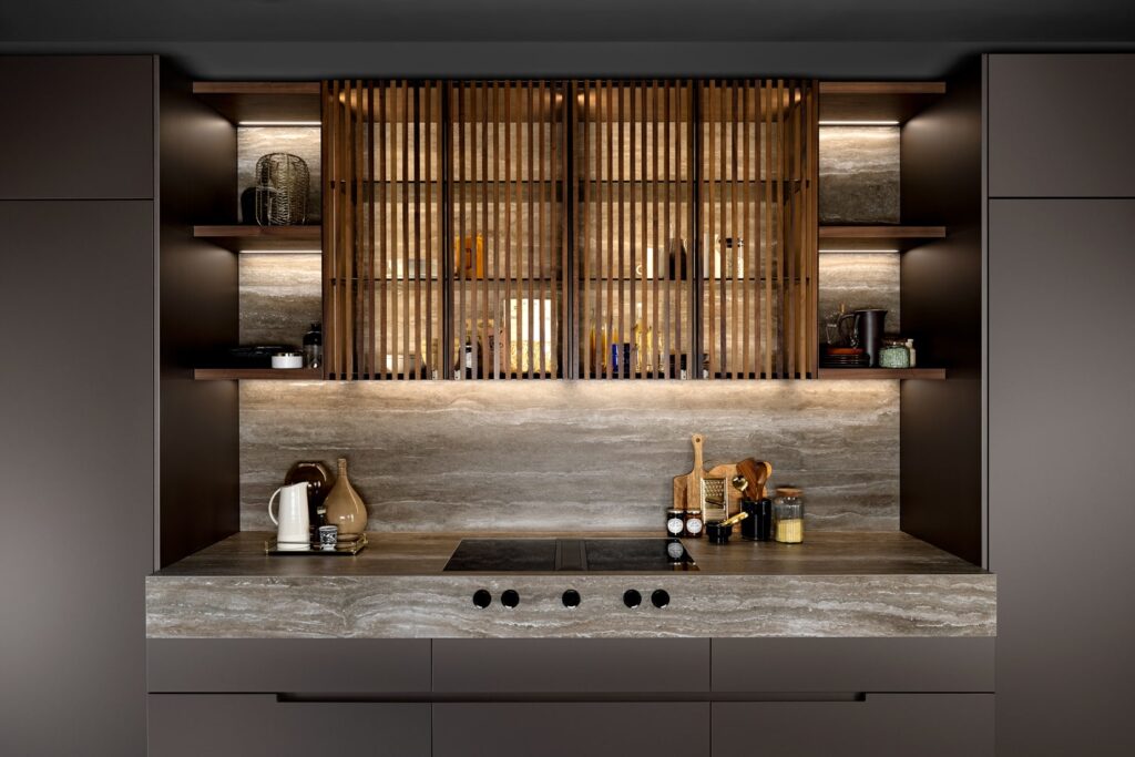 Luminous luxury kitchen cabinets made with a bronze frame and glass doors covered with Walnut strips.