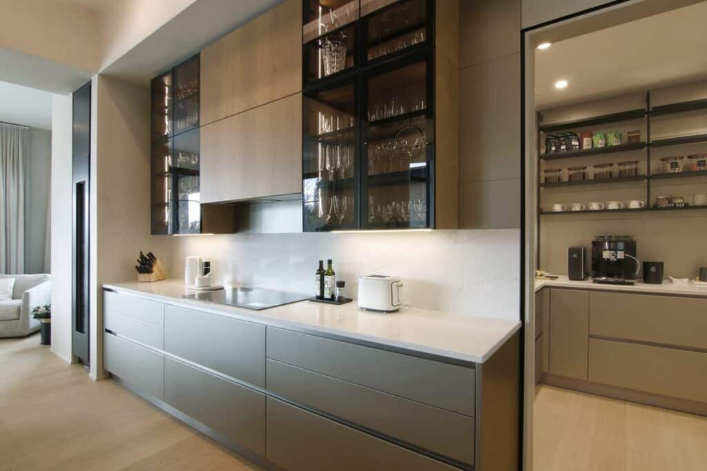 Luxury kitchen cabinetry in grey metal lacquer, Elm wood, and framed glass