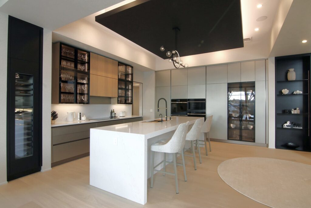 Luxury modern L-shaped kitchen with island. Italian cabinetry in metal lacquer, Elm wood, and framed glass.